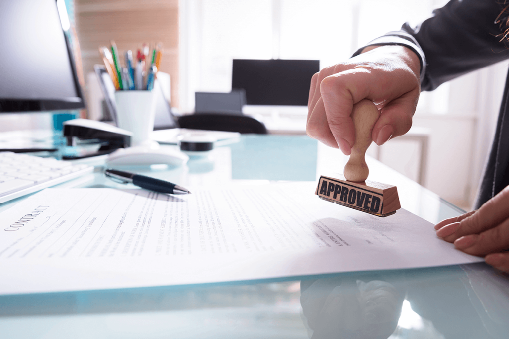 Businessperson stamping approved on contract paper